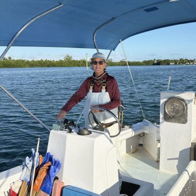 Captain Mimi Stafford drives her boat for derelict trap removal trips, while other volunteers handle the traps and collect data.